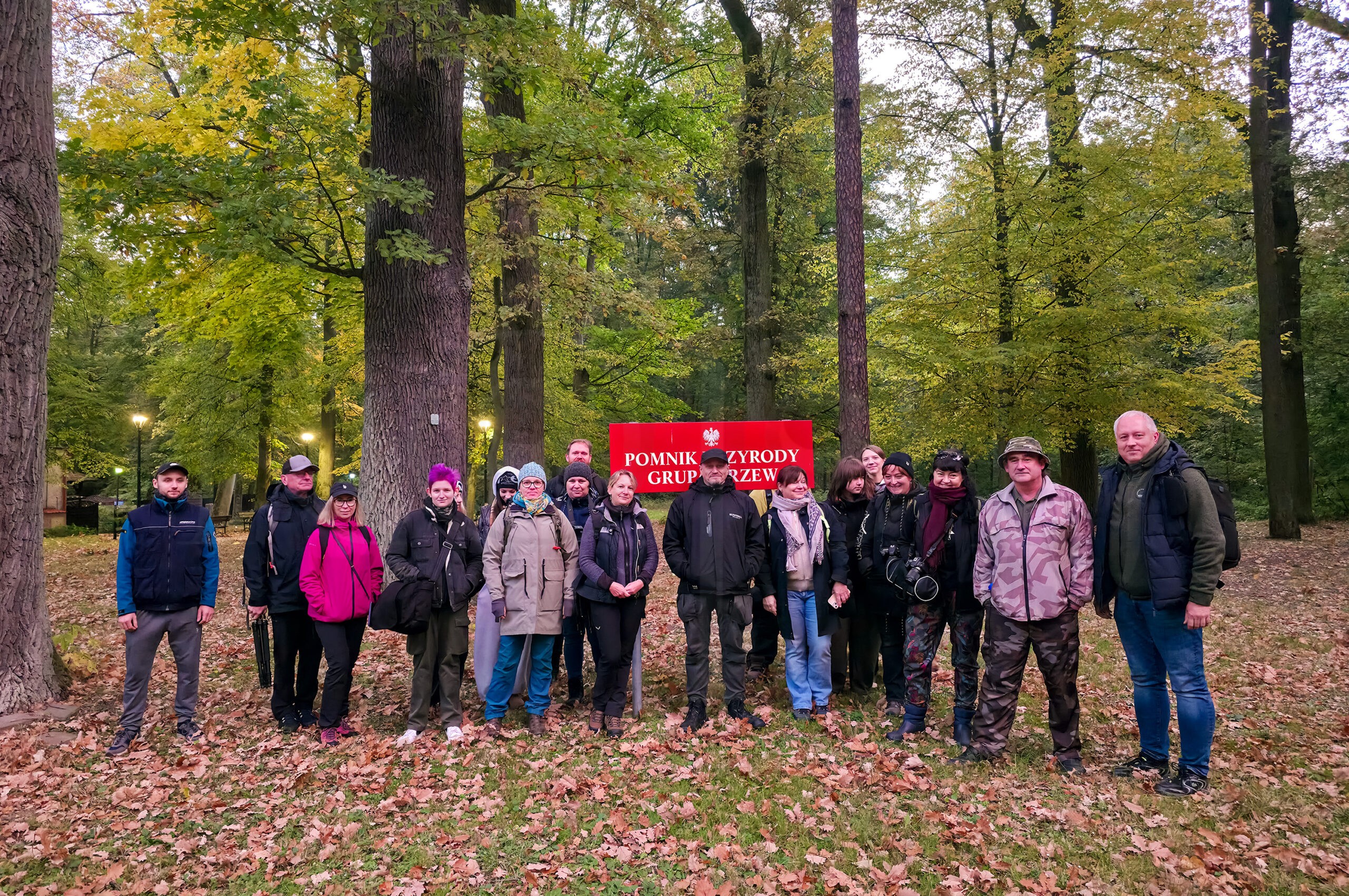 W sobotę, 17 października, odbył się kolejny plener fotograficzny w ramach inicjatywy „Pradolina Głogowska”. Tym razem wspólnie z Dariuszem Mikołajewiczem zabraliśmy uczestników do lasu, a konkretnie do malowniczej Leśnej Doliny w Gminie Kotla, gdzie jesienna przyroda stała się doskonałym pretekstem do fotograficznych eksperymentów, nauki i wymiany doświadczeń. Jesień to wyjątkowy czas dla fotografów przyrody. Leśne zakątki kryją mnóstwo drobnych detali, ciekawych faktur, barw i naturalnych kompozycji, które często umykają uwadze podczas zwykłego spaceru. Wystarczy zwolnić, przyjrzeć się bliżej otoczeniu i spojrzeć na las z nieco innej perspektywy. Właśnie na tym skupiliśmy się podczas naszego spotkania. Makrofotografia i odkrywanie małego świata Jednym z głównych tematów pleneru była makrofotografia, czyli sztuka pokazywania niewielkich obiektów i detali w sposób, który pozwala dostrzec ich niezwykłe piękno. Uczestnicy mogli eksperymentować z ustawieniami aparatu, głębią ostrości i kadrowaniem, szukając interesujących motywów w leśnym otoczeniu. Fotografia makro wymaga cierpliwości, uważności i precyzji. Niewielka zmiana położenia aparatu czy punktu ostrości potrafi całkowicie odmienić zdjęcie. To właśnie takie ćwiczenia pomagają lepiej zrozumieć możliwości własnego sprzętu i rozwijać fotograficzną wrażliwość. Focus bracketing i focus stacking, czyli większa głębia ostrości Drugim ważnym zagadnieniem były techniki focus bracketing i focus stacking, szczególnie przydatne w fotografii makro. Focus bracketing polega na wykonaniu serii zdjęć z przesuniętym punktem ostrości. Następnie, w technice focus stackingu, można połączyć wybrane kadry w jeden obraz, uzyskując większą głębię ostrości niż na pojedynczej fotografii. To rozwiązanie pozwala pokazać więcej detali na niewielkich obiektach, zachowując przy tym odpowiednią jakość obrazu. Podczas pleneru mogliśmy przyjrzeć się tej technice w praktyce, poznać jej możliwości i sprawdzić, jak wykorzystać ją we własnej fotografii przyrodniczej. Dopisała pogoda i frekwencja Październikowa aura okazała się dla nas łaskawa, a na miejscu pojawiło się sporo osób zainteresowanych fotografią. Cieszy nas, że kolejne spotkania przyciągają zarówno miłośników fotografii przyrodniczej, jak i osoby, które chcą rozwijać swoje umiejętności, poznawać nowe techniki i spędzać czas w otoczeniu natury. Takie plenery to nie tylko nauka obsługi aparatu. To również okazja do rozmów, wzajemnej inspiracji i wspólnego odkrywania miejsc, które mamy na wyciągnięcie ręki. Leśna Dolina w Gminie Kotla po raz kolejny pokazała, że nie trzeba jechać daleko, aby znaleźć ciekawe fotograficzne tematy. Kolejny plener fotograficzny już w listopadzie! Dziękujemy wszystkim uczestnikom za obecność, zaangażowanie i wspólnie spędzony czas. Podziękowania kierujemy również do Dariusza Mikołajewicza za współprowadzenie spotkania. Następny plener fotograficzny w ramach „Pradoliny Głogowskiej” planujemy już w listopadzie. Szczegóły dotyczące terminu, miejsca i tematyki spotkania podamy wkrótce. Warto śledzić aktualności, aby nie przegapić kolejnej okazji do fotografowania i rozwijania swoich umiejętności. Patronat nad plenerem objął Prezydent Miasta Głogowa Rafael Rokaszewicz. Do zobaczenia na kolejnych fotograficznych spotkaniach! 🙂